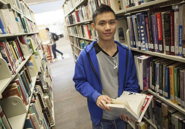 A Degree in Criminology student reading a book in the library
