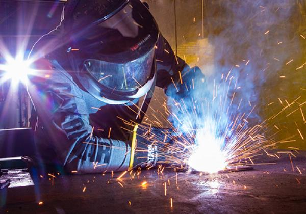 A welder working on a car.